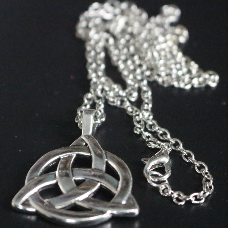 silver coloured triquetra necklace on a black background